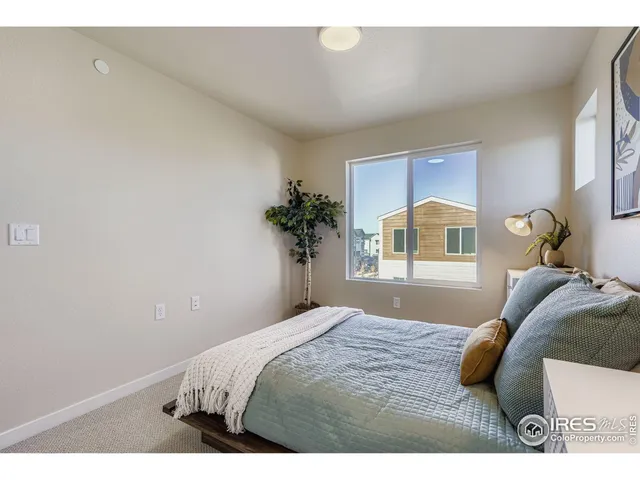 a bedroom with a bed and a large window