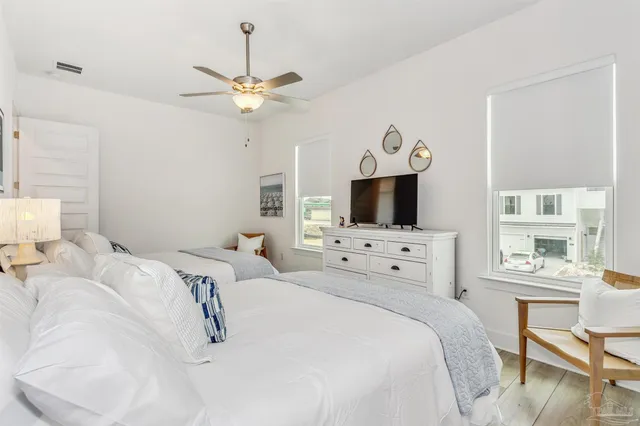 a bedroom with a large bed ceiling fan and a window