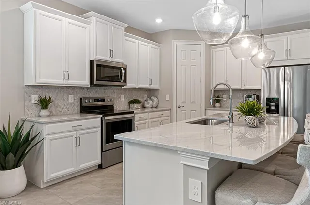 a kitchen with stainless steel appliances granite countertop a sink a stove and cabinets