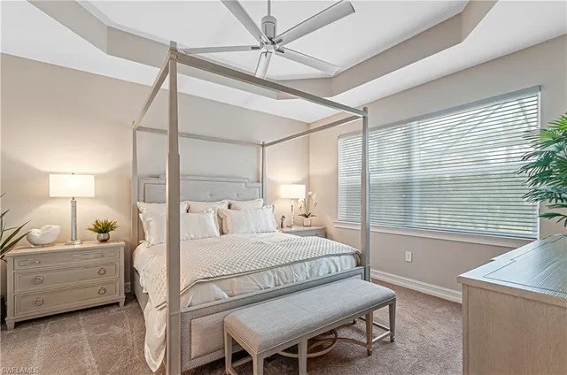 a bedroom with a bed a chandelier and a window