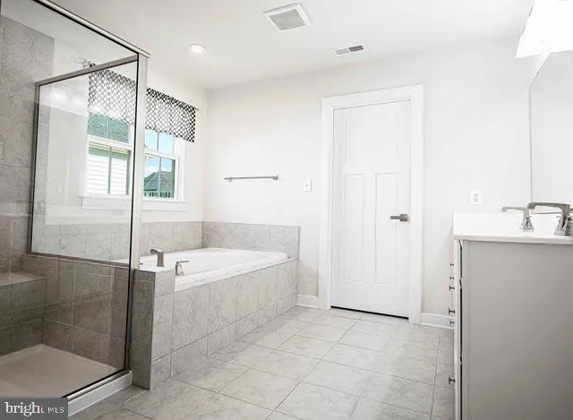 a bed sitting in a bedroom next to a window and dresser