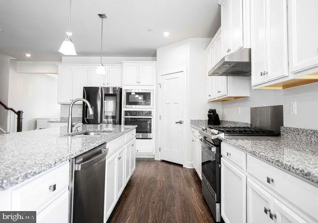 a large kitchen with lots of counter space a sink appliances and cabinets