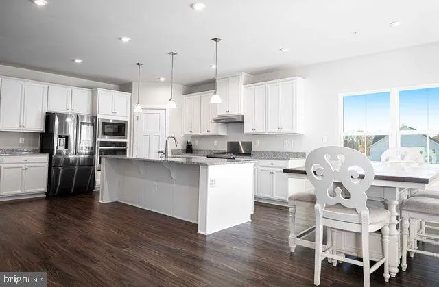 a kitchen with stainless steel appliances granite countertop a sink a stove and a refrigerator