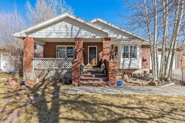 a view of a house with a small yard and wooden fence