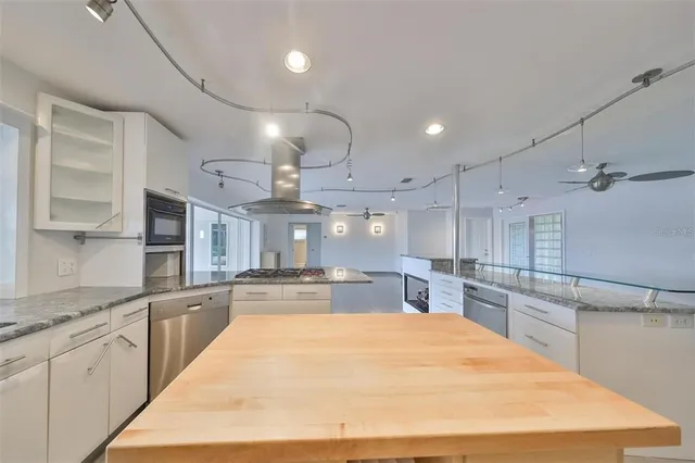 a large kitchen with kitchen island a sink stainless steel appliances and cabinets
