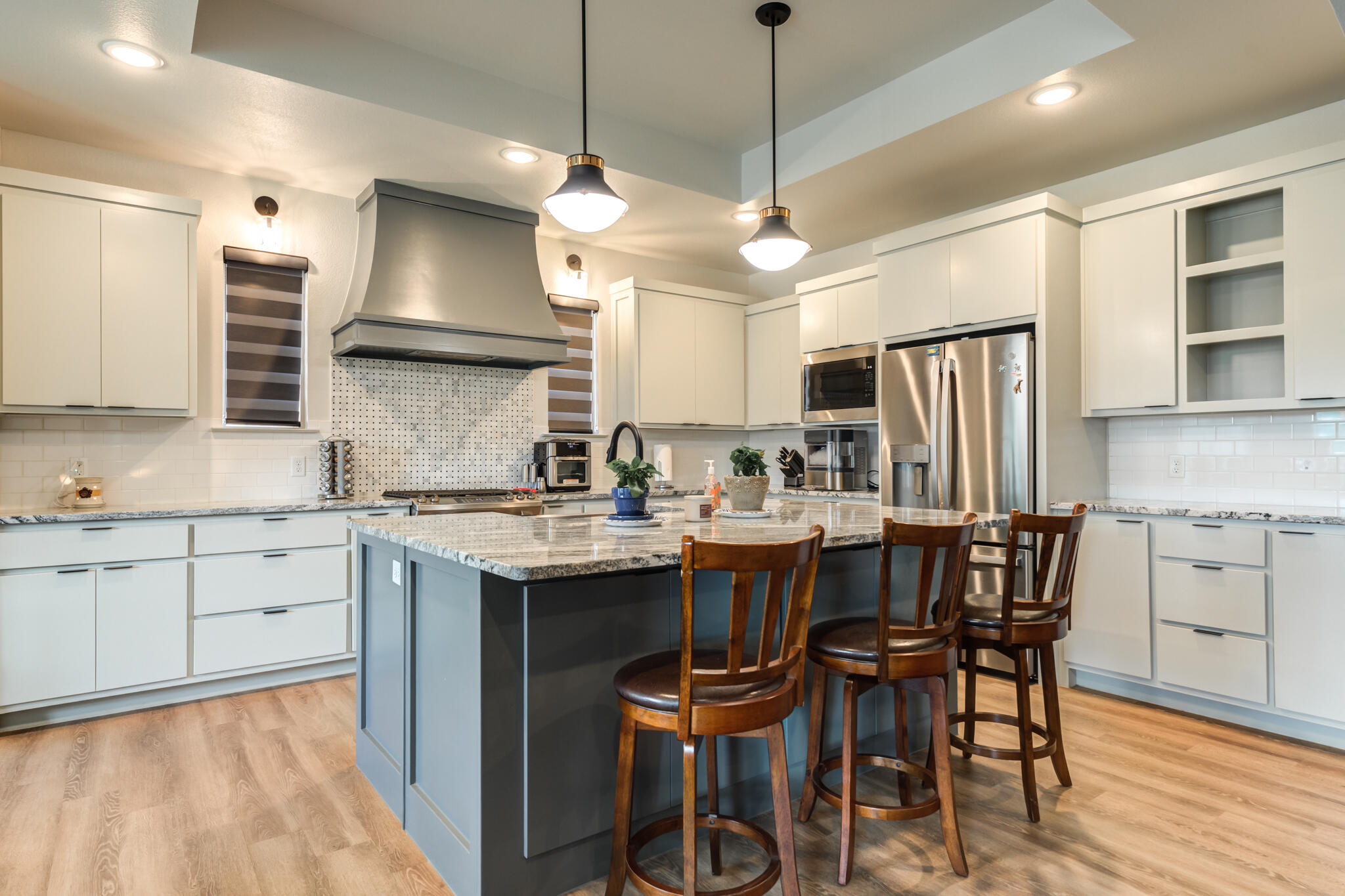 5722 118th Street Lubbock, TX 79424 - Photo 10 of 30 a kitchen with kitchen island granite countertop a sink a center island and stainless steel appliances