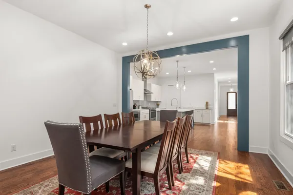 a dining room with furniture wooden floor a rug and a chandelier