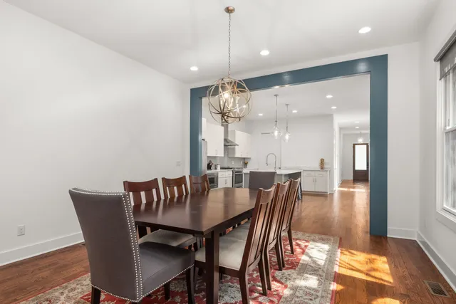 a dining room with furniture wooden floor a rug and a chandelier