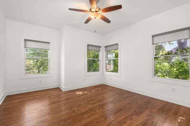 a view of room with window ceiling fan and hardwood floor