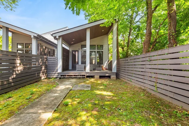 a view of a house with backyard and sitting area