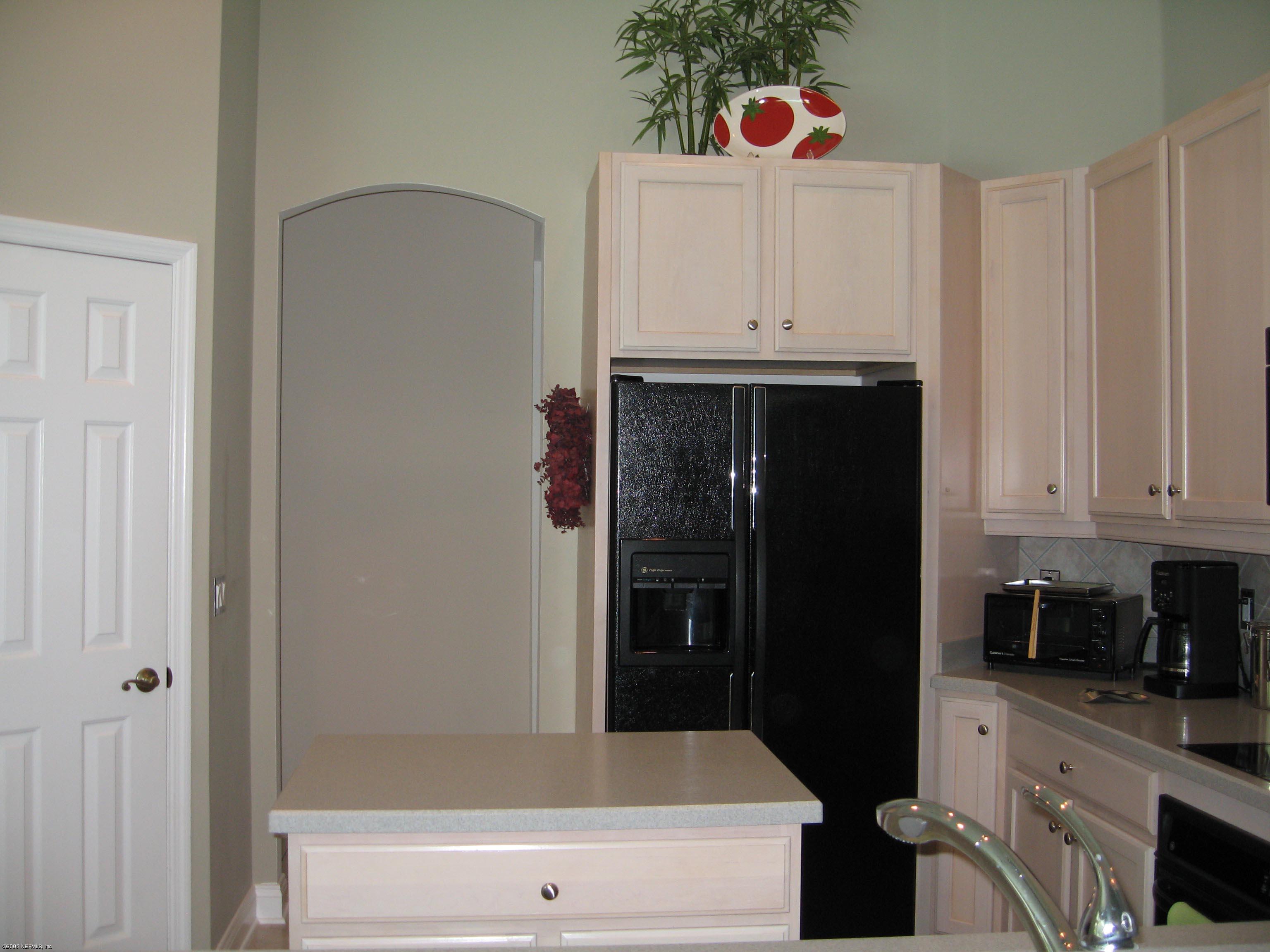 753 Mill Stream Road Ponte Vedra Beach, FL 32082 - Photo 7 of 16 a kitchen with white cabinets and refrigerator