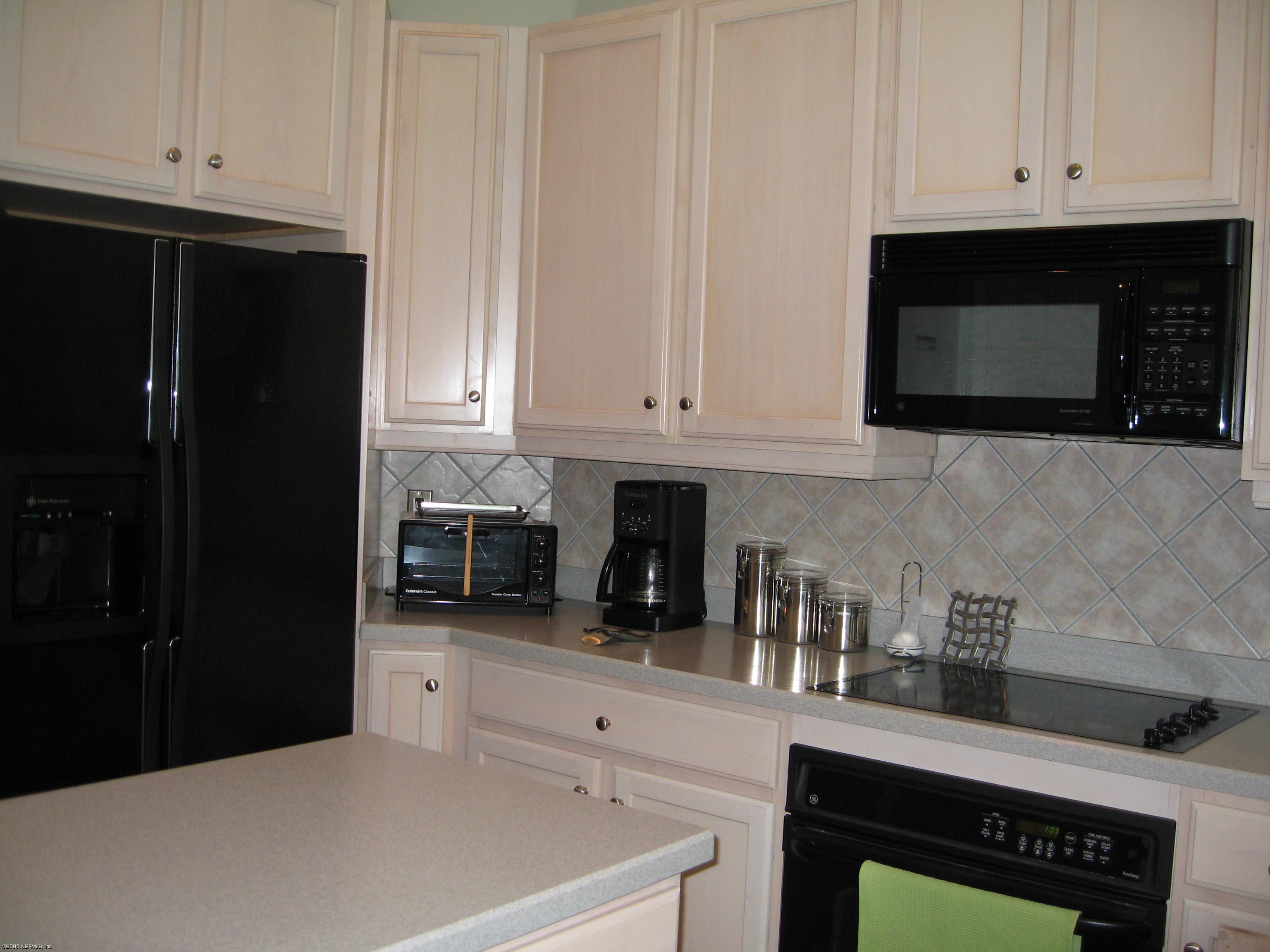 753 Mill Stream Road Ponte Vedra Beach, FL 32082 - Photo 8 of 16 a kitchen with stainless steel appliances a stove a microwave a sink and cabinets