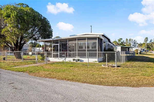 a large pool is sitting in front of a house with a yard