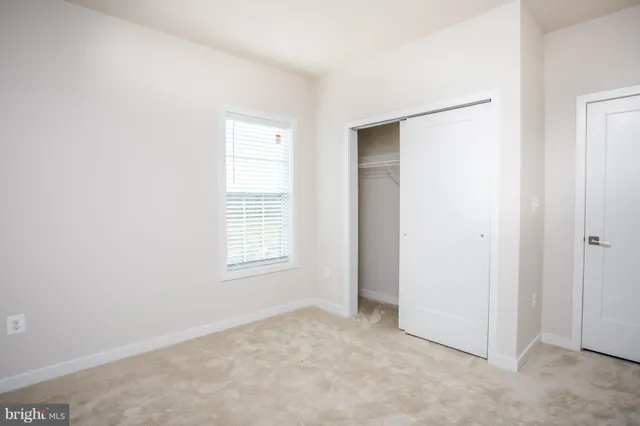 an empty room with windows and closet
