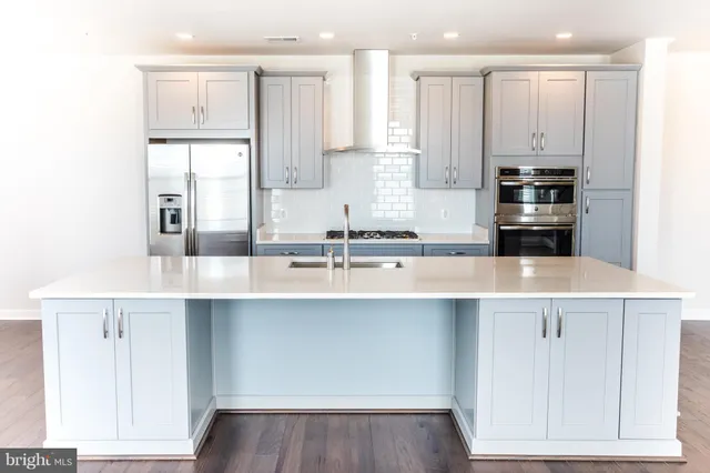 a kitchen with kitchen island white cabinets and stainless steel appliances