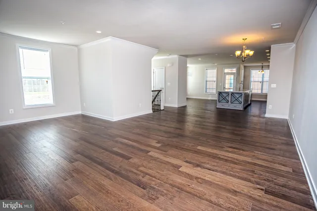 a view of empty room with wooden floor and window