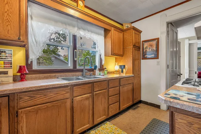 a kitchen with stainless steel appliances granite countertop a stove a sink dishwasher and cabinets with wooden floor