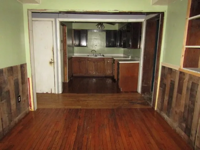 a view of a hallway with wooden floor and staircase
