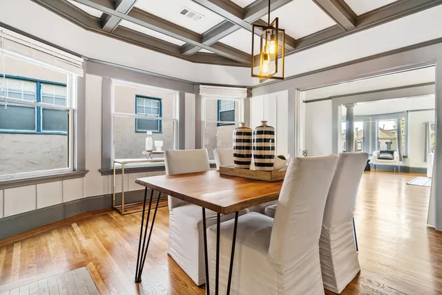 a dining room with furniture a chandelier and wooden floor