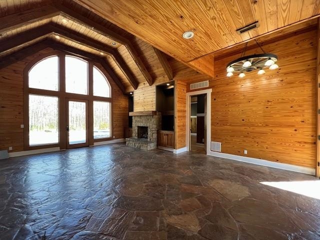 9490 Highway 196 Collierville, TN 38017 - Photo 1 of 40 Open-concept interior featuring expansive arched windows, natural wood plank walls, exposed wood beam vaulted ceilings, a stone fireplace, and large format natural stone flooring