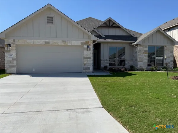 a front view of a house with a yard and trees