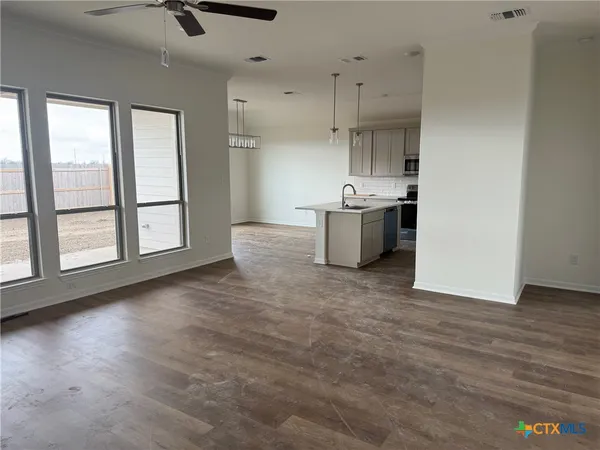 a kitchen with stainless steel appliances granite countertop a sink a stove and a wooden floors