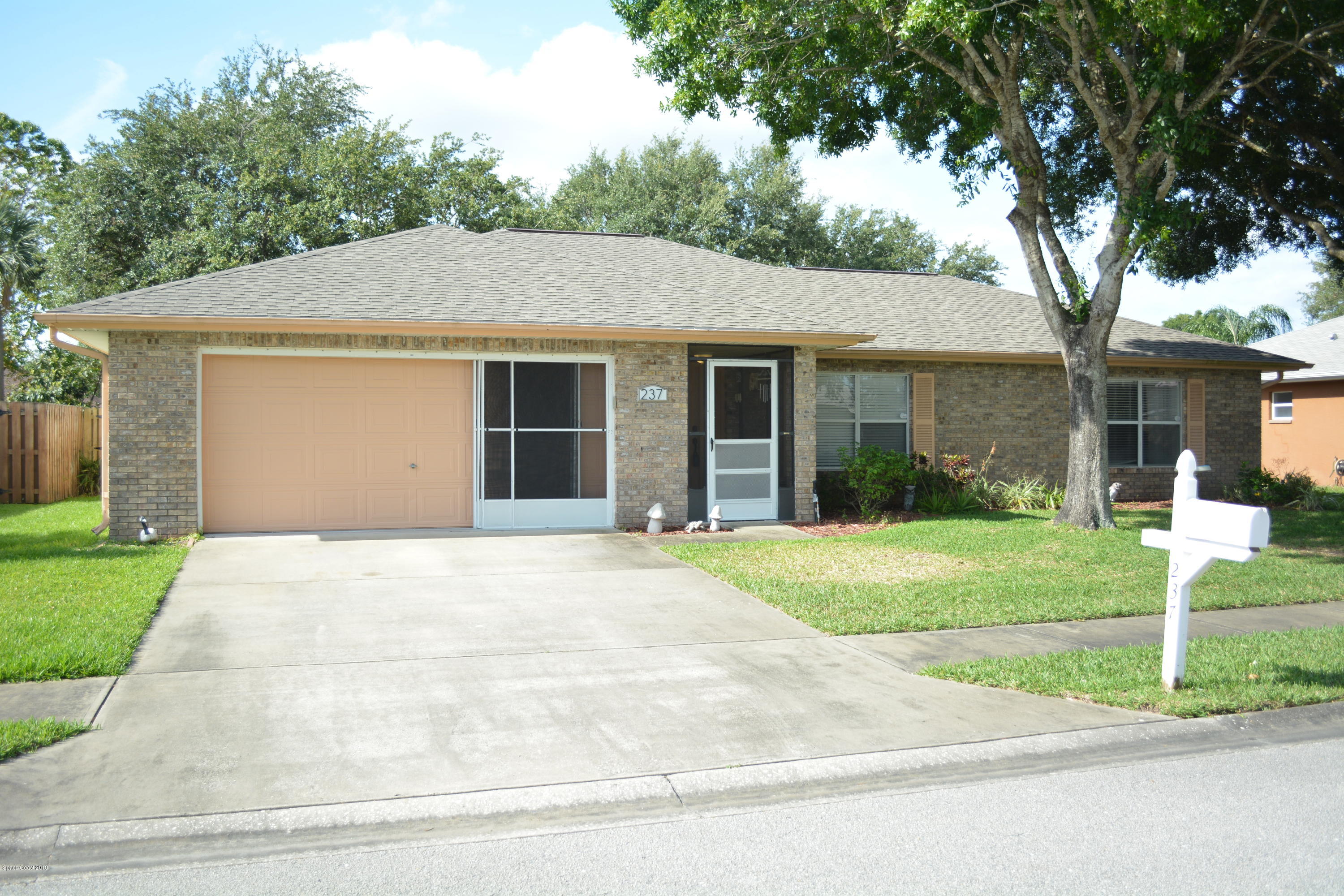 237 Crystal Lake Road Melbourne, FL 32901 - Photo 14 of 15 a front view of a house with a yard and garage