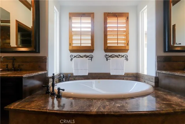 a bathroom with a tub sink and mirror