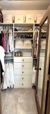 a view of walk in closet with clothes and shoes