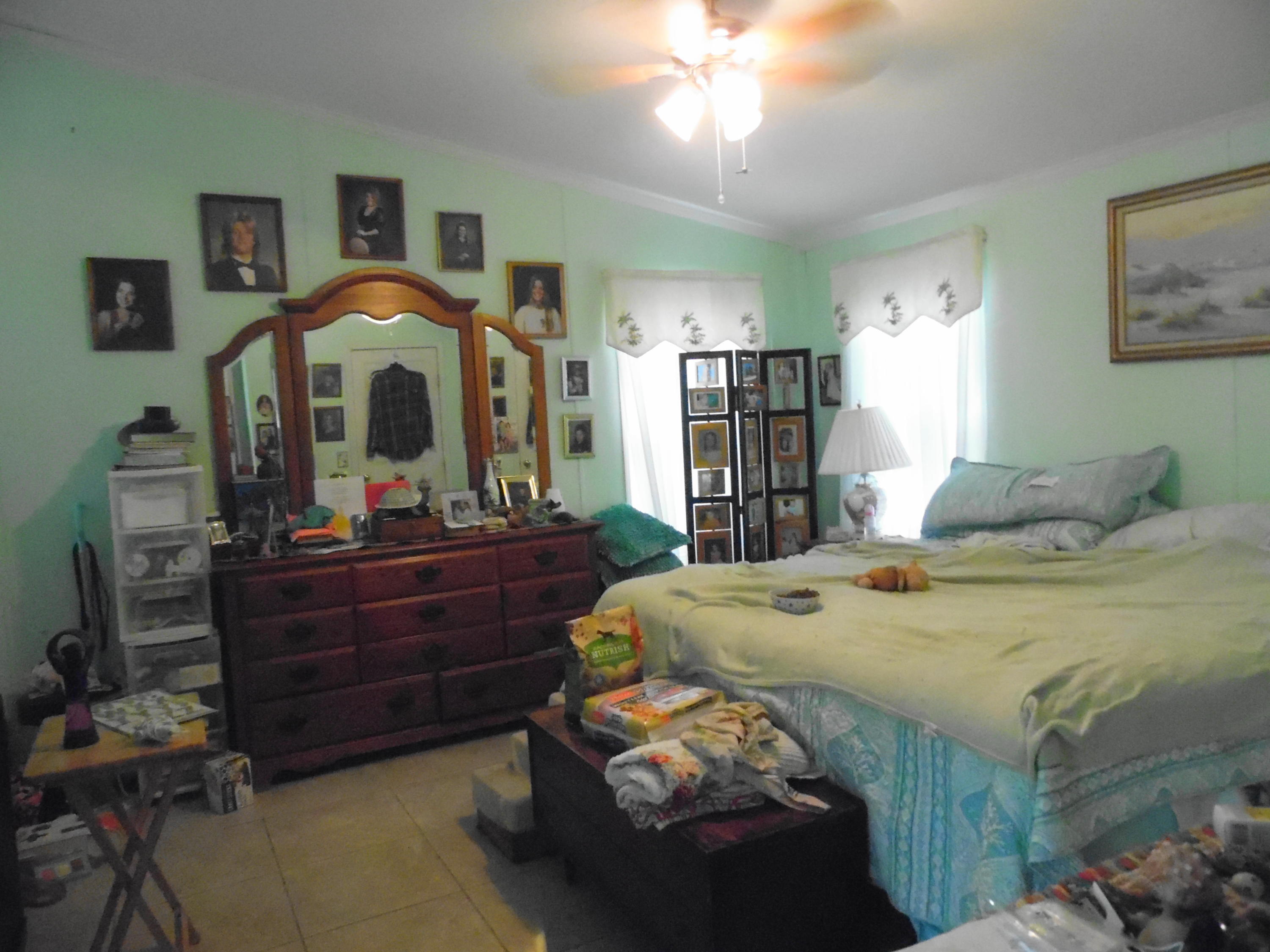 642 Elmwood Road DeFuniak Springs, FL 32433 - Photo 23 of 37 a bed room with a bed and a chandelier