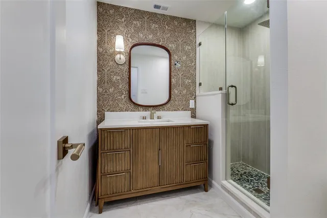 a bathroom with a sink mirror and shower