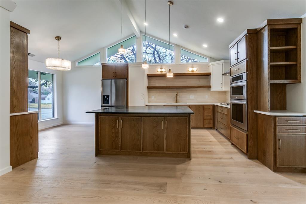 4371 Mill Creek Road Dallas, TX 75244 - Photo 10 of 33 a kitchen with stainless steel appliances granite countertop a sink a stove and a wooden floors