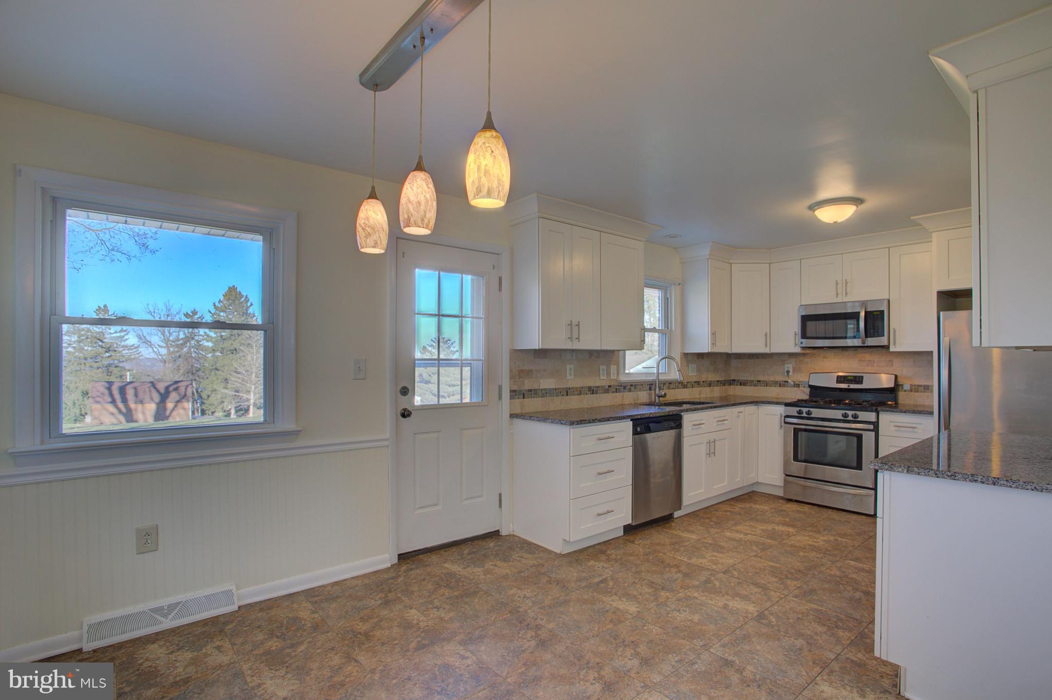1047 Letort Road Conestoga, PA 17516 - Photo 5 of 30 a kitchen with stainless steel appliances granite countertop a stove a sink dishwasher and a refrigerator with wooden floor