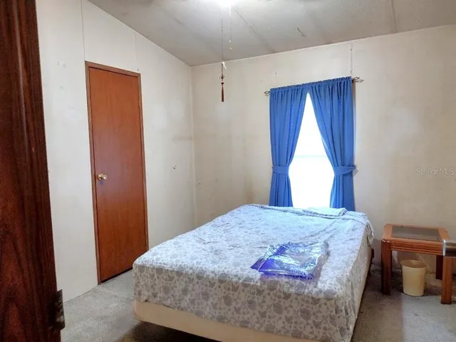 a bedroom with a bed and a window