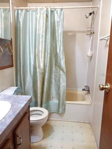 a bathroom with a granite countertop bathtub shower sink and toilet