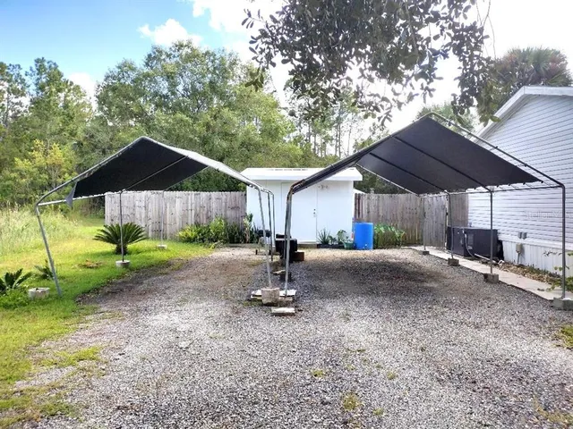 a view of a house with backyard and trees