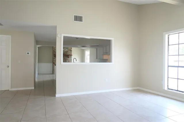 an empty room with a bathroom and a window