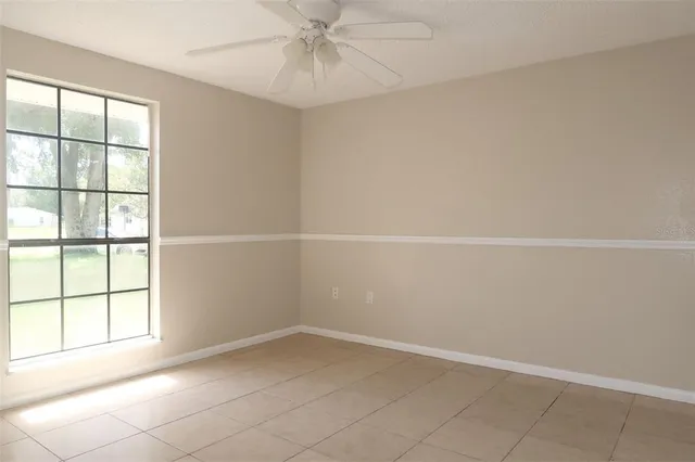 an empty room with a window and a fan