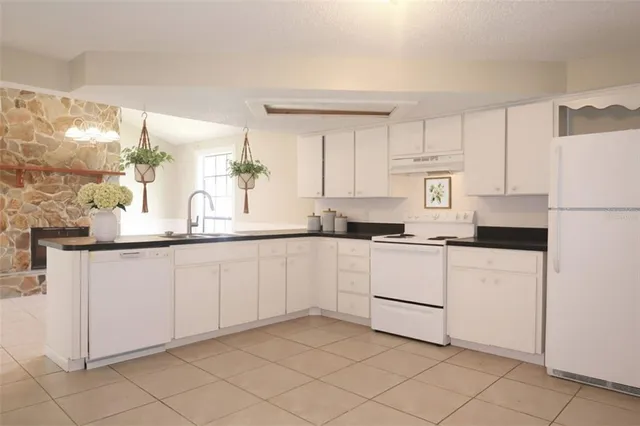 a kitchen with white cabinets and white appliances