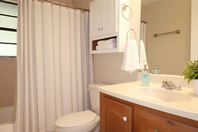 a bathroom with a sink a toilet and shower curtain