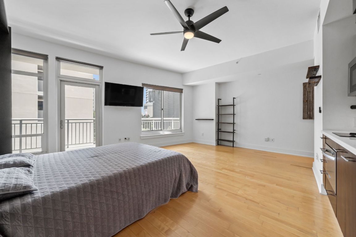 603 Davis Street, Unit 710 Austin, TX 78701 - Photo 2 of 37 a bedroom with a large bed and a flat tv screen on dresser