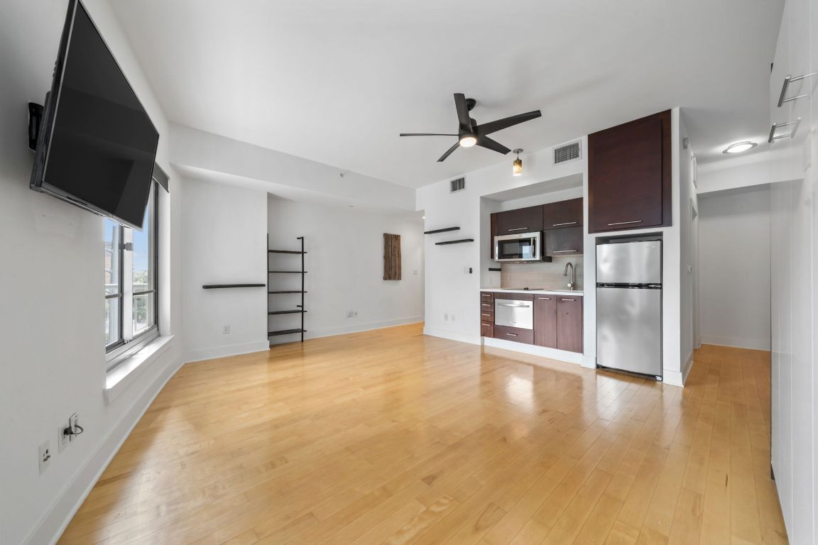 603 Davis Street, Unit 710 Austin, TX 78701 - Photo 5 of 37 a view of a kitchen with refrigerator and wooden floor