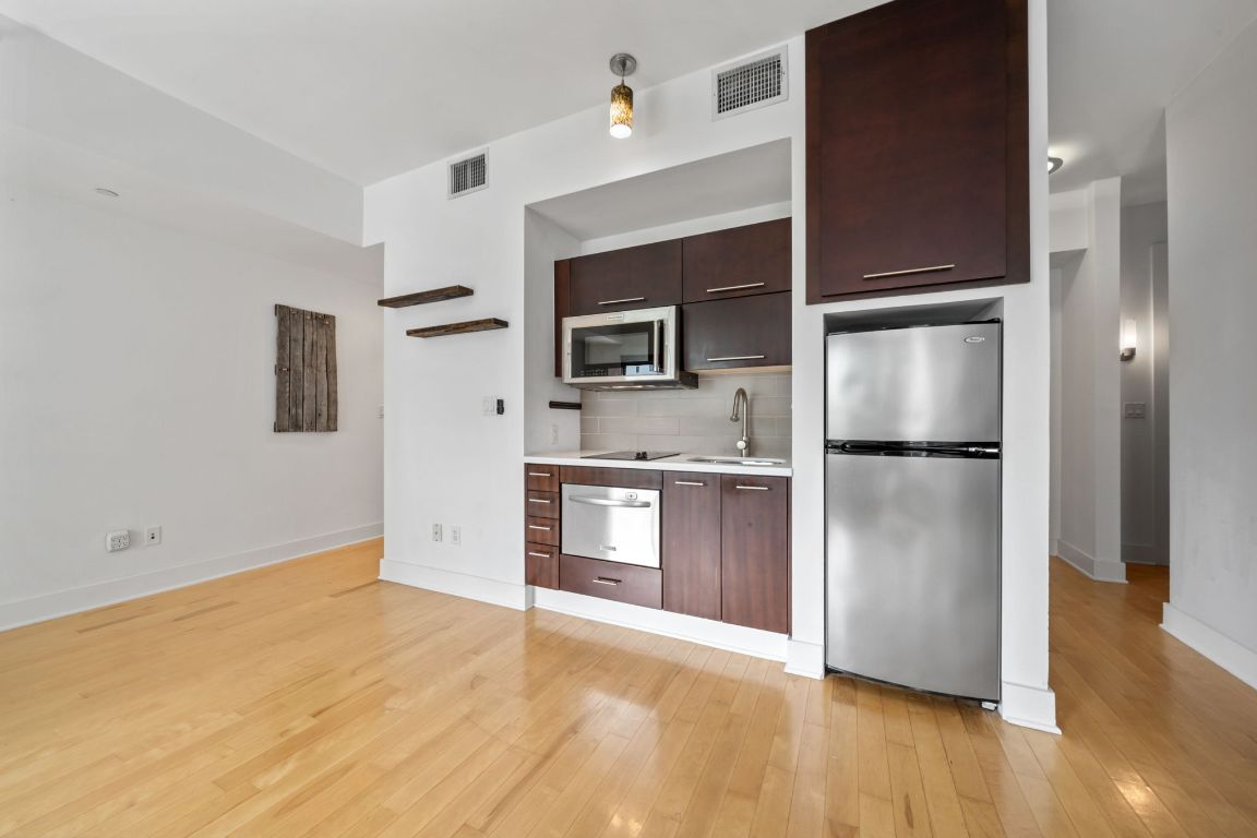 603 Davis Street, Unit 710 Austin, TX 78701 - Photo 7 of 37 a kitchen with granite countertop a refrigerator and a sink