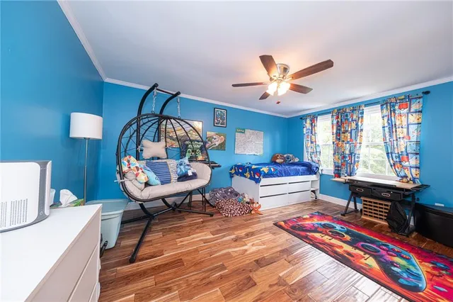 a bedroom with a bed and a bookshelf with wooden floor