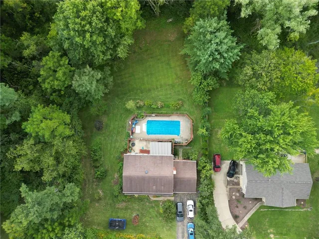 an aerial view of residential houses with outdoor space and trees