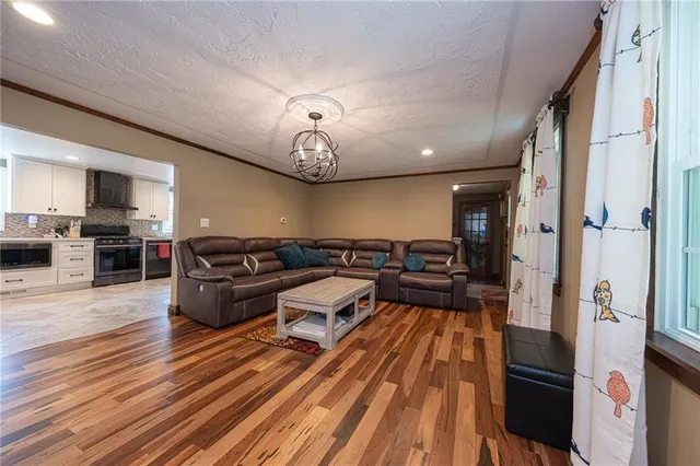 a view of a living room and kitchen with furniture wooden floor