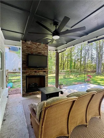 a living room with a fireplace a flat screen tv and a floor to ceiling window