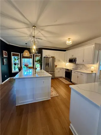 a large kitchen with stainless steel appliances granite countertop a large counter top and a stove