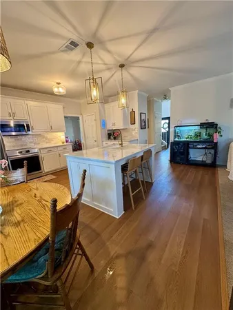 a view of a dining room with furniture a rug and wooden floor