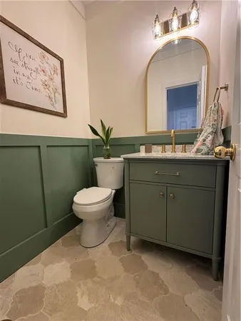 a bathroom with a toilet sink and mirror